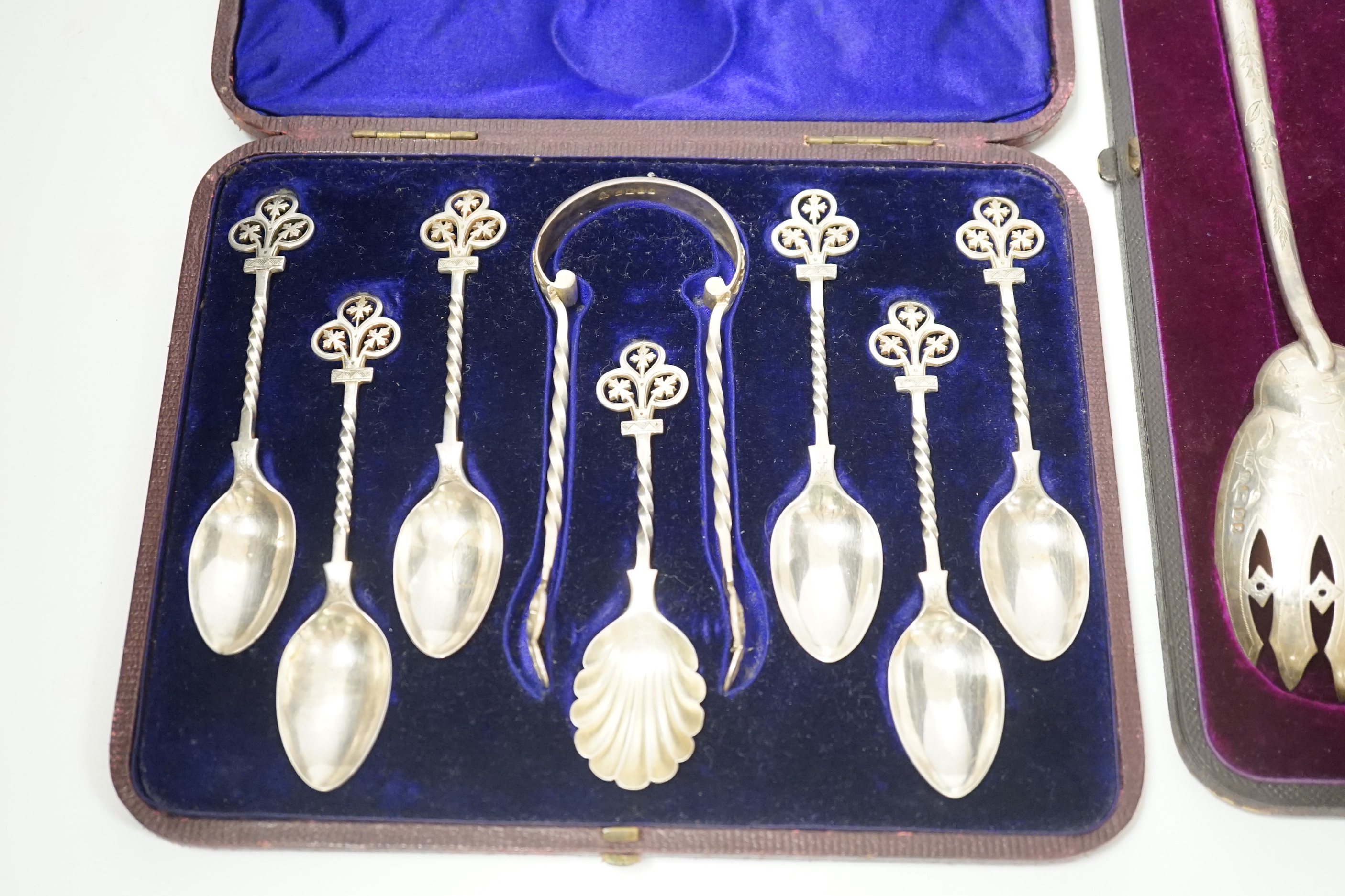 A cased pair of Victorian aesthetic period silver salad servers, Atkin Brothers, Sheffield, 1881 and a cased set of silver teaspoons, sugar spoon and tongs.